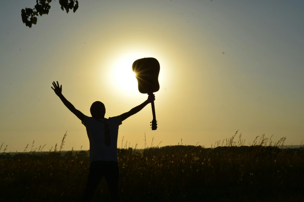 pexels-photo-89909-89909 A young guitarist celebrates the sunrise after learning how to play with beginner guitar lessons!